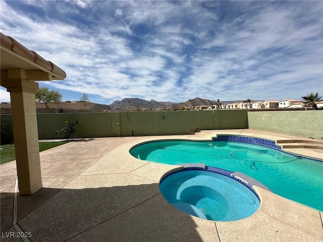 view of swimming pool with a mountain view, a patio, a fenced backyard, and a pool with connected hot tub