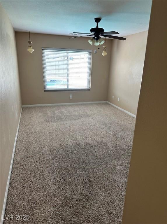 empty room featuring carpet floors, ceiling fan, and baseboards