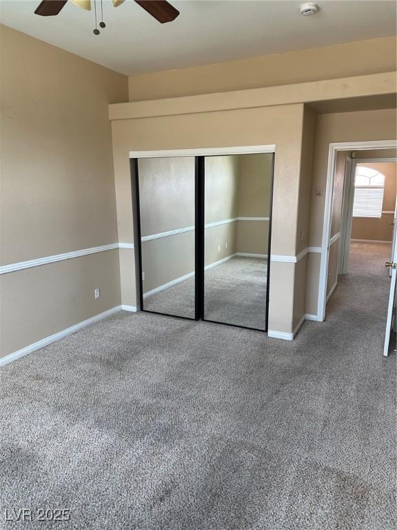 unfurnished bedroom featuring a ceiling fan, a closet, and baseboards