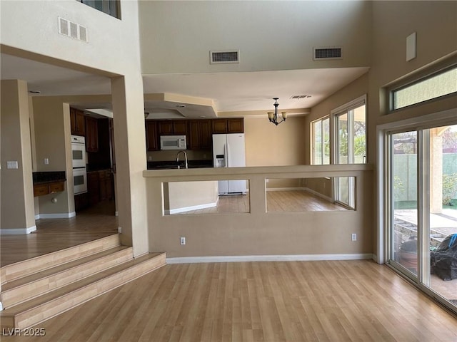 interior space featuring white appliances, light wood-type flooring, and visible vents