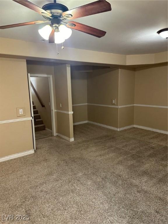 below grade area featuring stairs, baseboards, and a ceiling fan