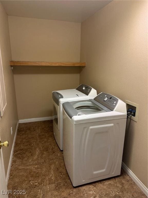 washroom with laundry area, washing machine and clothes dryer, and baseboards