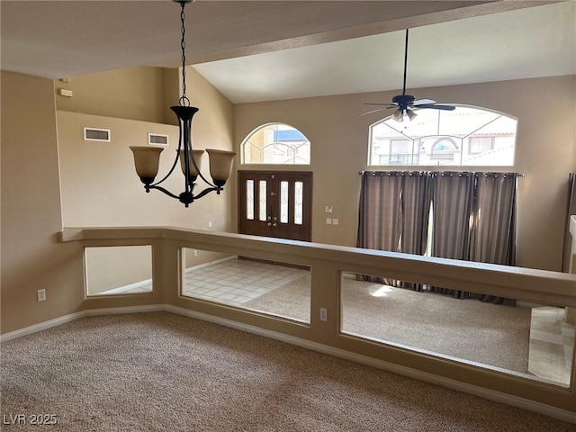 interior space featuring carpet, visible vents, baseboards, and ceiling fan with notable chandelier