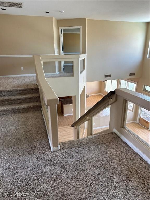 stairs with visible vents and carpet flooring