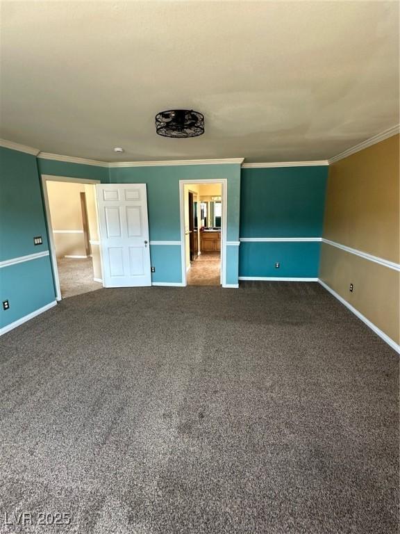 unfurnished bedroom featuring dark colored carpet, ornamental molding, and baseboards