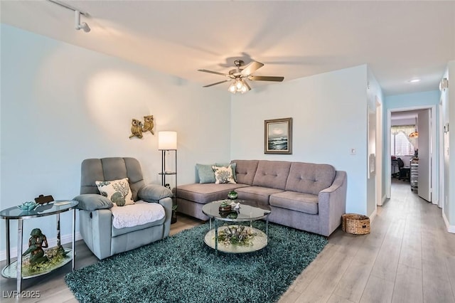 living area featuring ceiling fan, track lighting, and wood finished floors