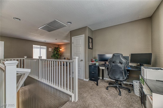 office space featuring a textured ceiling, carpet, visible vents, and baseboards