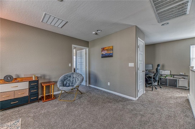 carpeted office featuring baseboards, visible vents, a textured ceiling, and a textured wall