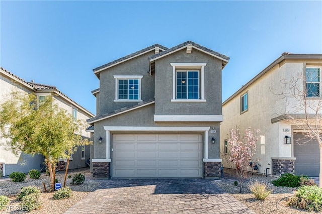 view of front of home with an attached garage, stone siding, decorative driveway, and stucco siding