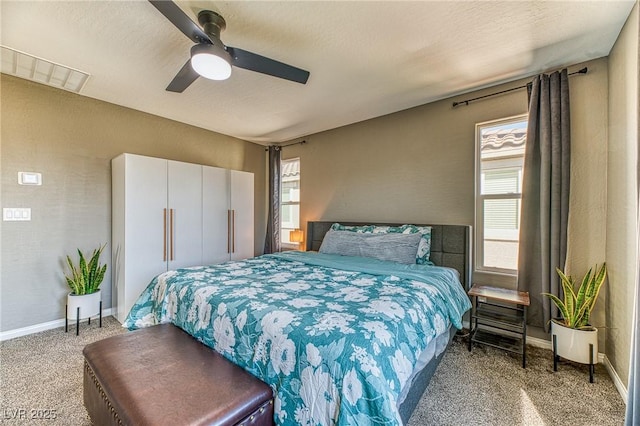 bedroom featuring multiple windows, carpet, a ceiling fan, and baseboards