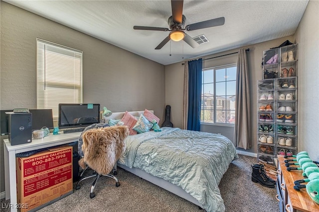 bedroom with visible vents, a ceiling fan, a textured wall, a textured ceiling, and carpet flooring