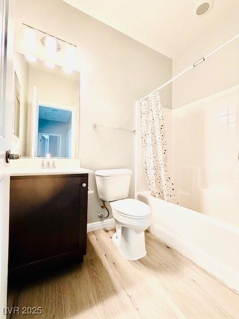 full bathroom with toilet, wood finished floors, vanity, baseboards, and shower / tub combo with curtain