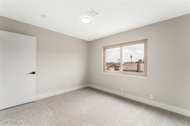 empty room featuring carpet, visible vents, and baseboards