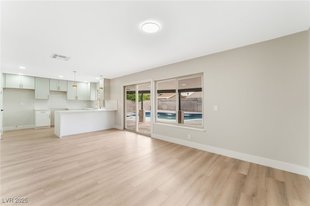 unfurnished living room featuring recessed lighting, visible vents, light wood-style flooring, and baseboards