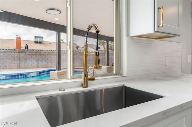 room details with light stone counters and a sink