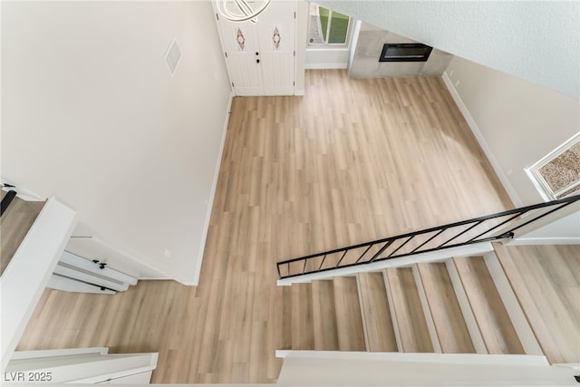 stairs featuring baseboards, visible vents, and wood finished floors