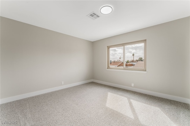 carpeted empty room featuring baseboards and visible vents