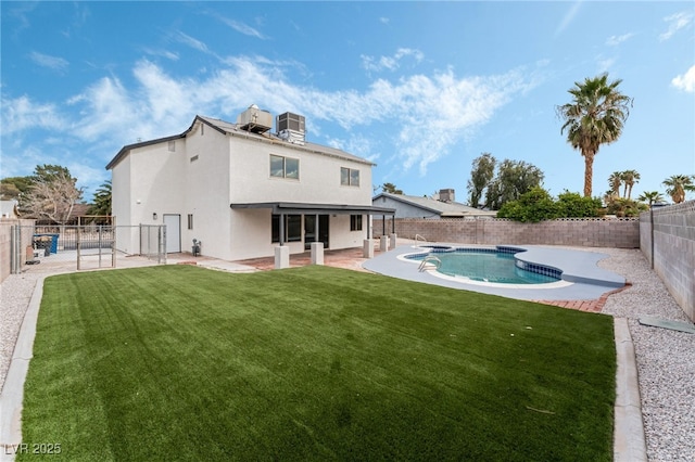 back of property with a fenced in pool, a patio, a fenced backyard, a yard, and stucco siding