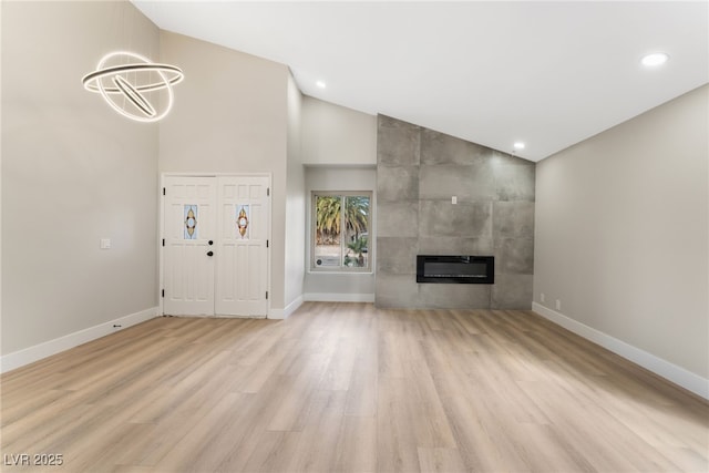 unfurnished living room with baseboards, a tile fireplace, and light wood-style floors