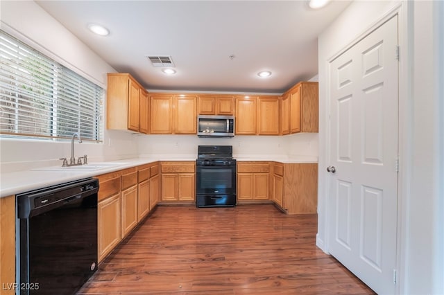 kitchen with visible vents, wood finished floors, black appliances, a sink, and recessed lighting