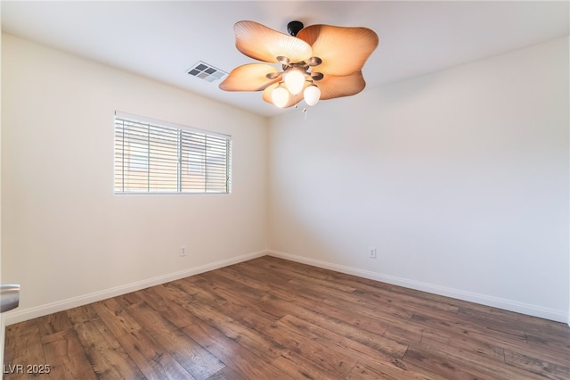 empty room with visible vents, ceiling fan, baseboards, and wood finished floors