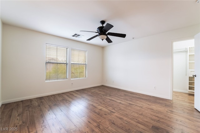 unfurnished room featuring ceiling fan, wood-type flooring, visible vents, and baseboards