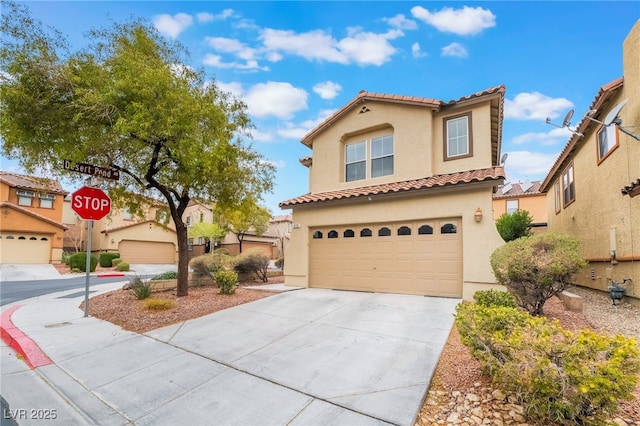 mediterranean / spanish house featuring a garage, driveway, and stucco siding