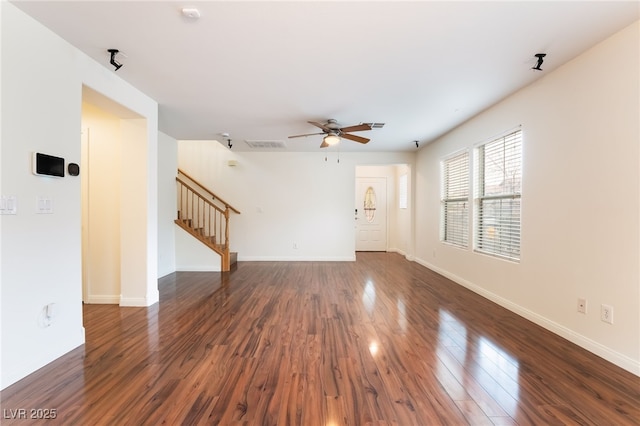 unfurnished living room featuring dark wood-style floors, visible vents, stairway, and baseboards