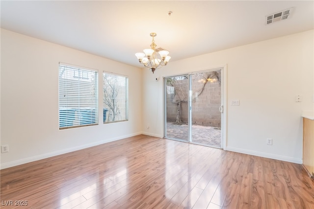 unfurnished dining area featuring a chandelier, light wood-type flooring, visible vents, and baseboards