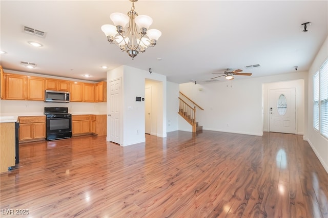 unfurnished living room featuring light wood-type flooring, visible vents, and stairs