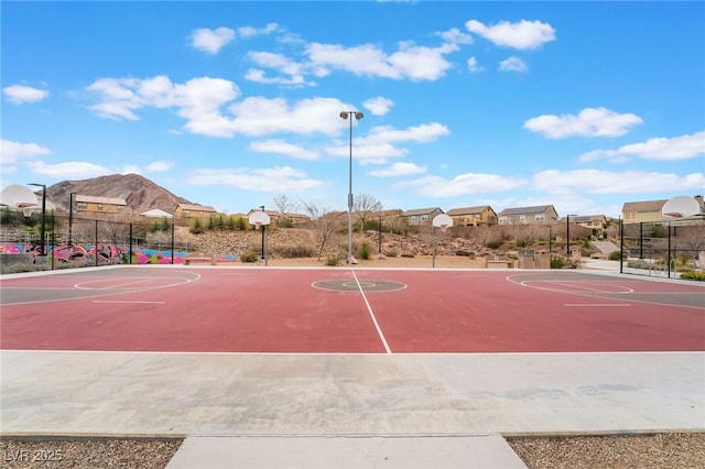 view of basketball court with community basketball court, fence, and a residential view