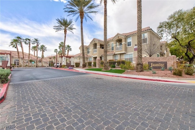 view of road with curbs, a residential view, a gated entry, and sidewalks