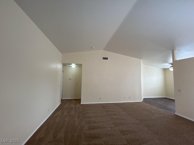 carpeted spare room featuring a ceiling fan, lofted ceiling, visible vents, and baseboards