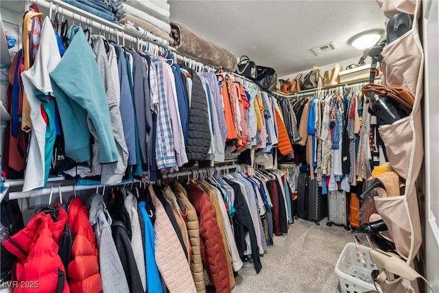 walk in closet featuring visible vents and carpet flooring