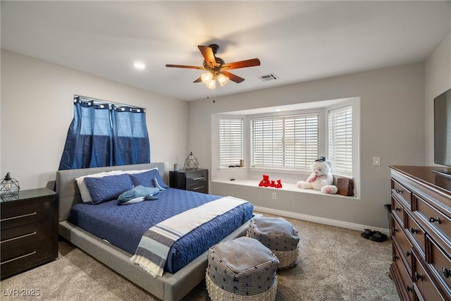 carpeted bedroom with visible vents, baseboards, and a ceiling fan