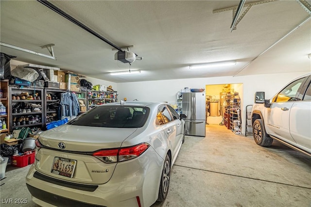 garage with a garage door opener and freestanding refrigerator