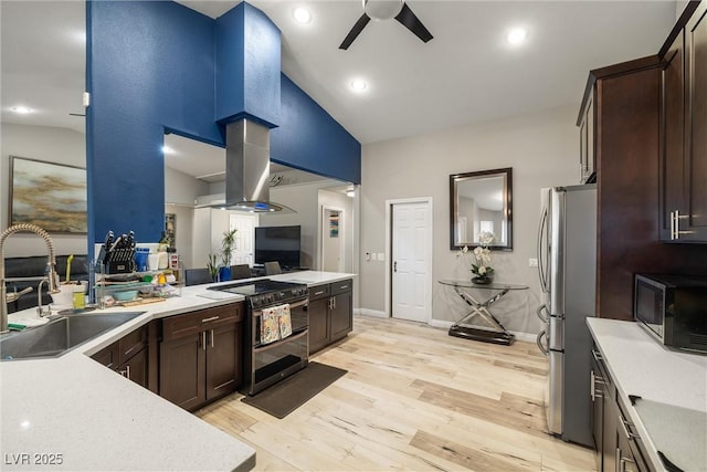 kitchen with dark brown cabinetry, light countertops, range with two ovens, freestanding refrigerator, and a sink