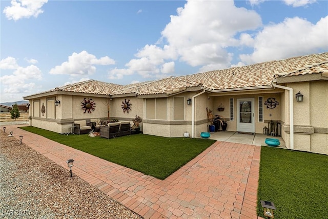 back of property with a patio, a yard, stucco siding, outdoor lounge area, and a tiled roof