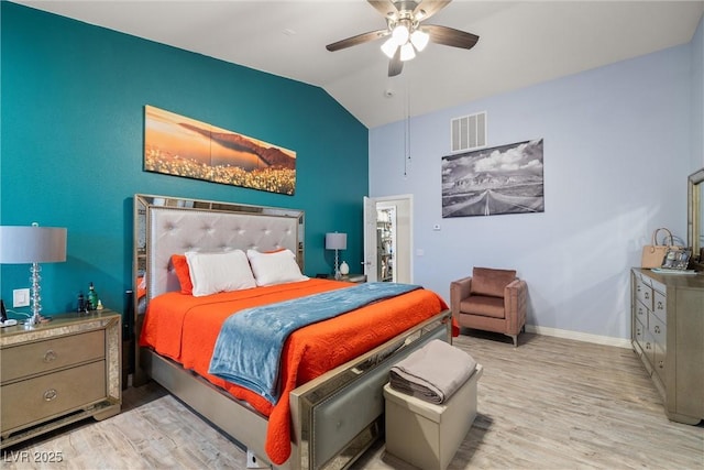 bedroom featuring visible vents, baseboards, lofted ceiling, and wood finished floors