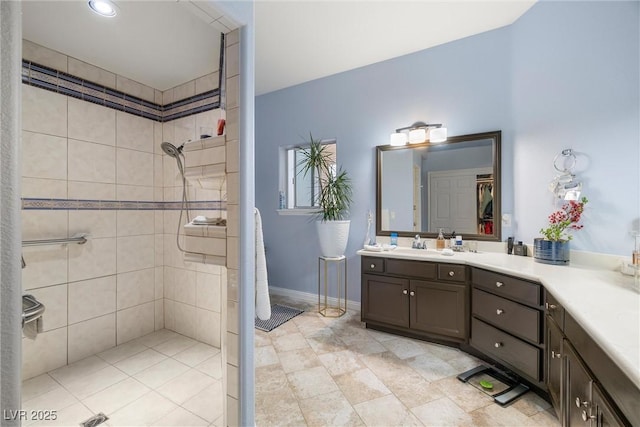 bathroom featuring tiled shower and vanity