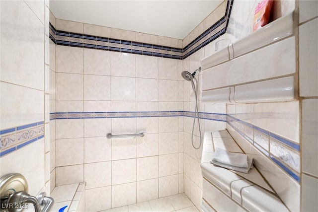 bathroom with tiled shower, tile walls, and tile patterned flooring