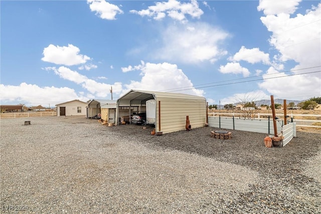 view of outdoor structure with a carport and fence