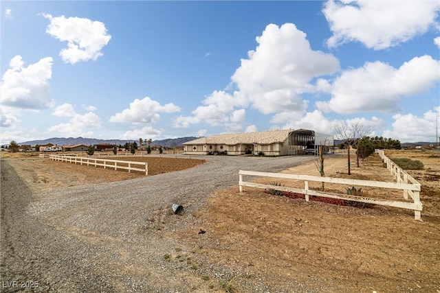 view of yard featuring a carport, a rural view, and fence