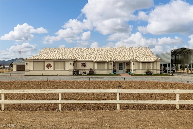 view of front of house with a tile roof, a carport, and stucco siding