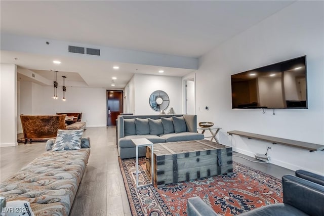 living area featuring recessed lighting, visible vents, baseboards, and wood finished floors