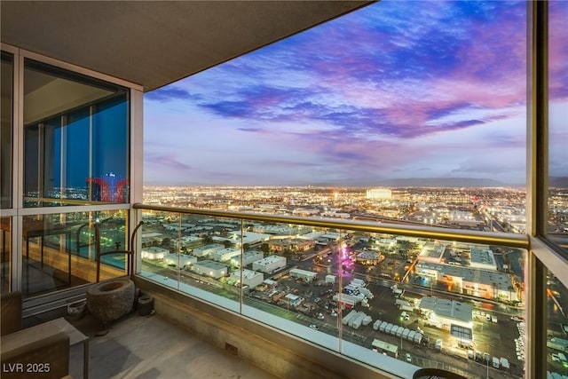 balcony at dusk featuring a city view