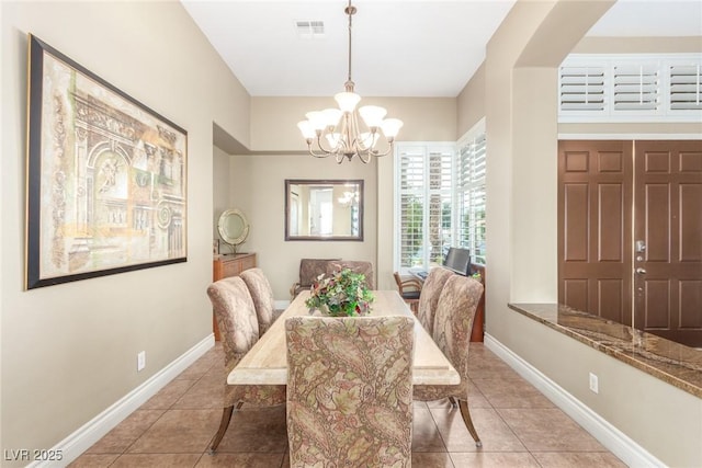 tiled dining space featuring visible vents, baseboards, and an inviting chandelier