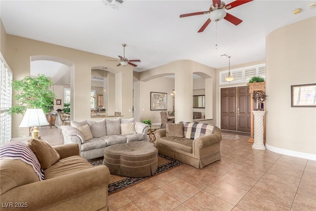 living room with light tile patterned floors, visible vents, baseboards, and a ceiling fan