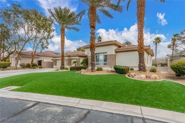 mediterranean / spanish house featuring a front yard, concrete driveway, fence, and stucco siding