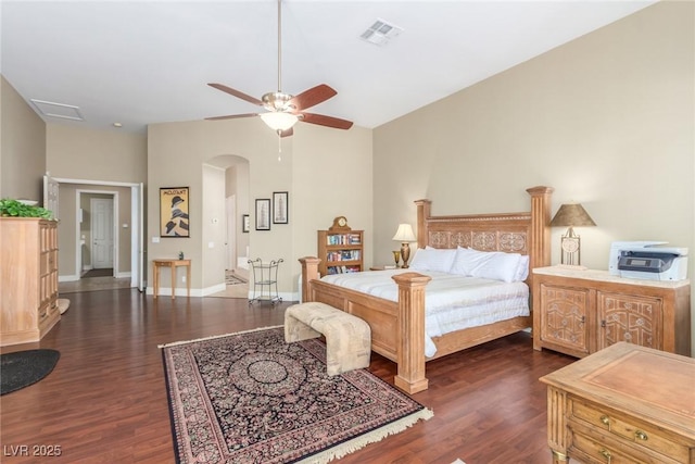 bedroom with baseboards, visible vents, dark wood finished floors, arched walkways, and ceiling fan